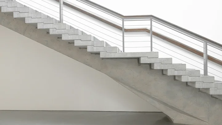 Concrete staircases and metal railings in a light-filled museum.